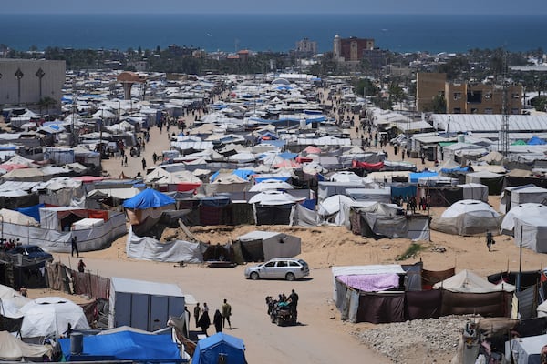 Displaced Palestinians walk through a makeshift tent camp in the Muwasi area of Khan Younis, in the Gaza Strip, on Monday, May 5, 2025. (AP Photo/Abdel Kareem Hana)