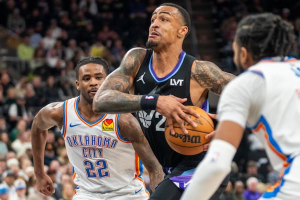FILE - Utah Jazz forward John Collins, middle, takes the ball up the middle, as Oklahoma City Thunder guard Cason Wallace (22) and Oklahoma City Thunder guard Isaiah Joe, right, defend, during the second half of an NBA basketball game Feb. 21, 2025, in Salt Lake City. (AP Photo/Rick Egan, File)