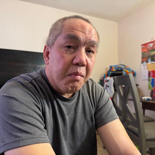 Chongly "Scott" Thao, a U.S. citizen, sits for a photo at his home Monday, Jan. 19, 2026, in St. Paul, Minn., the day after federal agents broke open his door and detained him without a warrant. (AP Photo/Jack Brook)