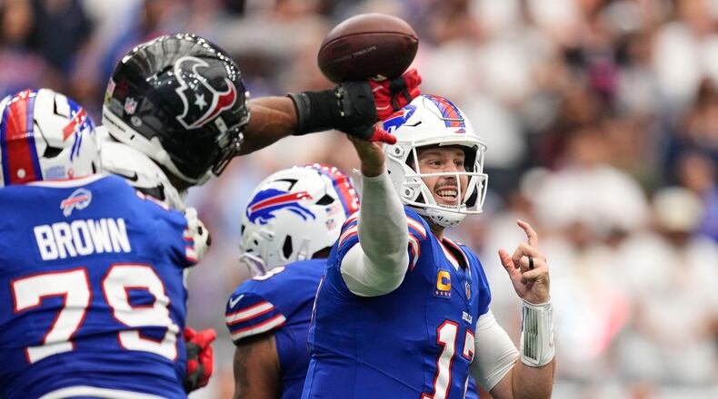 Buffalo Bills quarterback Josh Allen (17) throws an incomplete pass forced by Houston Texans defensive end Danielle Hunter, second from left, during the second half of an NFL football game, Sunday, Sept. 13, 2026, in Houston. (AP Photo/Ashley Landis)