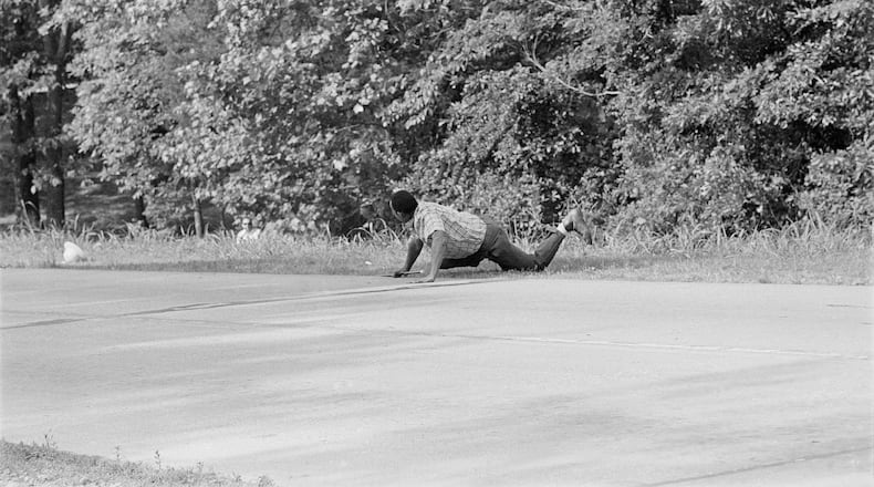 FILE - James Meredith looks at Aubrey James Norvell, background left partially hidden behind foliage, after being shot on a road near Hernando, Miss., June 6, 1966. (AP Photo/Jack Thornell, File)