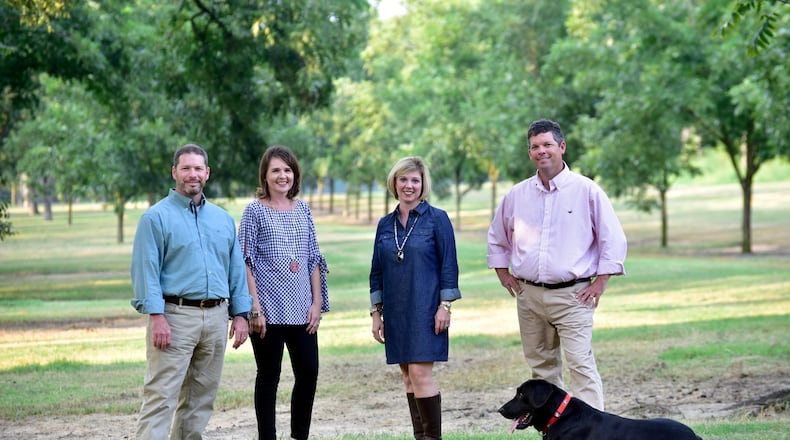 Pecan Ridge Plantation is a family operation headed by (left to right) Rob Cohen and his wife, Rebecca, Mollie Cohen and her husband Eric. Black lab Tate, the company's truffle hunter, is at Eric's feet. (Photo credit: Todd Stone Photography)
