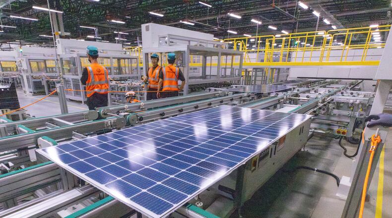 Workers keep an eye on the solar panels as they move through the automated assembly line at the Qcells module production facility in Cartersville on Tuesday, April 2, 2024.  (Steve Schaefer/steve.schaefer@ajc.com)