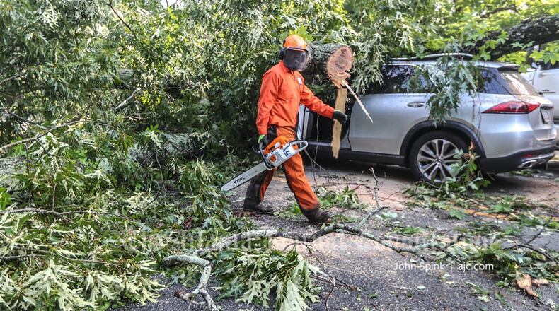 Authorities worked to reopen Clairemont Avenue in Decatur after a tree fell across the road Wednesday morning and crushed an SUV.