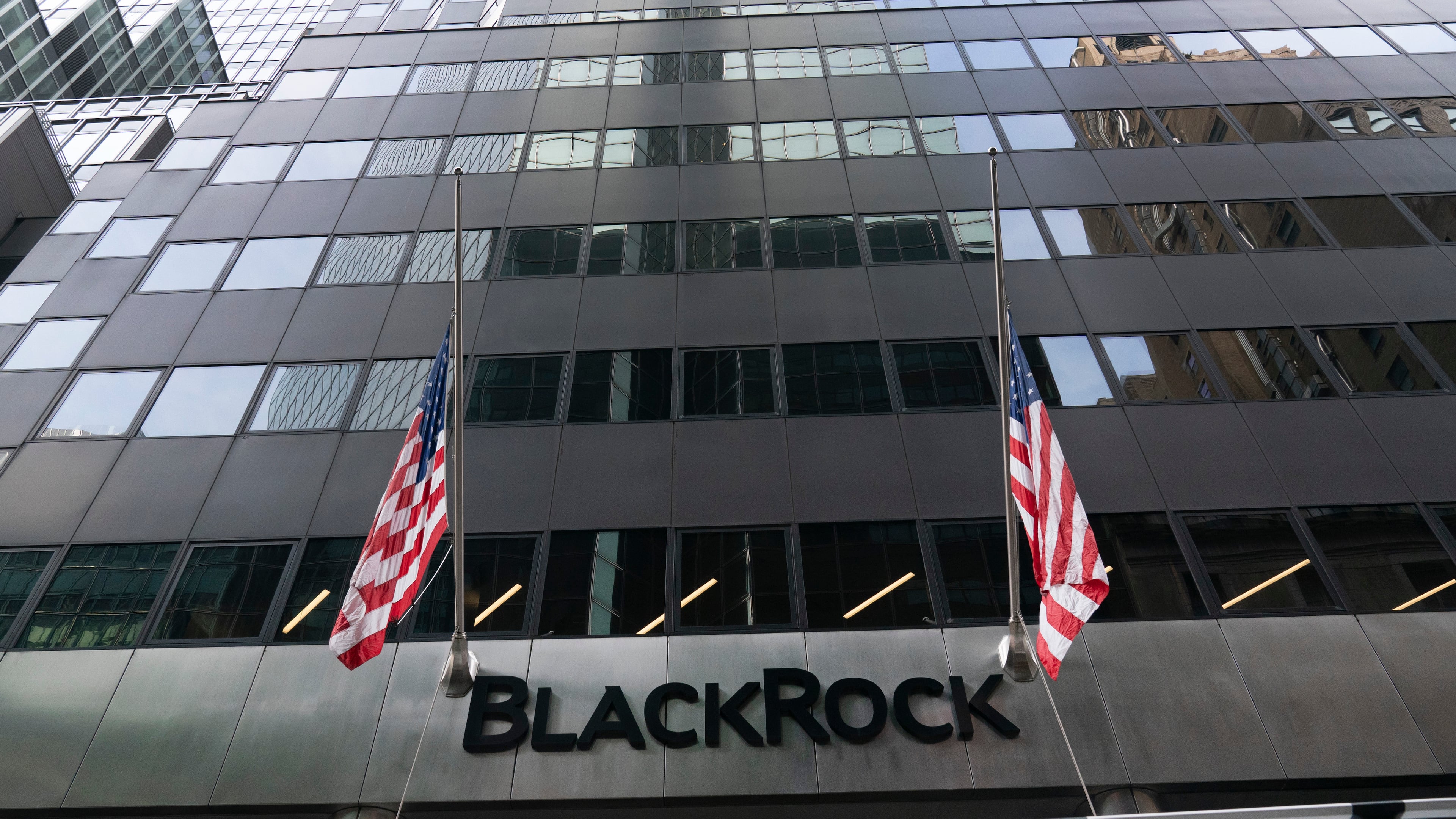 FILE -Flags fly on the front of BlackRock headquarters, Wednesday, Jan. 13, 2021, in New York. . (AP Photo/Mark Lennihan, File)