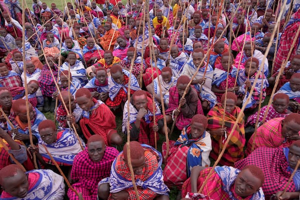 Children of the Maasai tribe gather around during the Enkipaata ceremony, a Maasai male rite of passage, specifically the initiation of boys, marking the transition from childhood to becoming a moran (warrior) in Olaimutiai, Narok County, Kenya Thursday, April 24, 2024. (AP Photo/Brian Inganga)