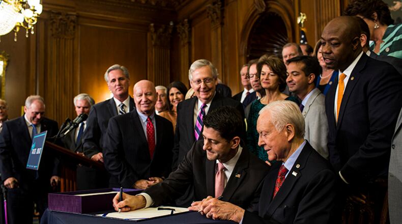 House Speaker Paul Ryan, R-Wis., and Sen. Orrin Hatch, R-Utah, sign an enrollment for the conference report to H.R. 1, the Tax Cuts and Jobs Act, on Capitol Hill in Washington on Dec. 21, 2017.