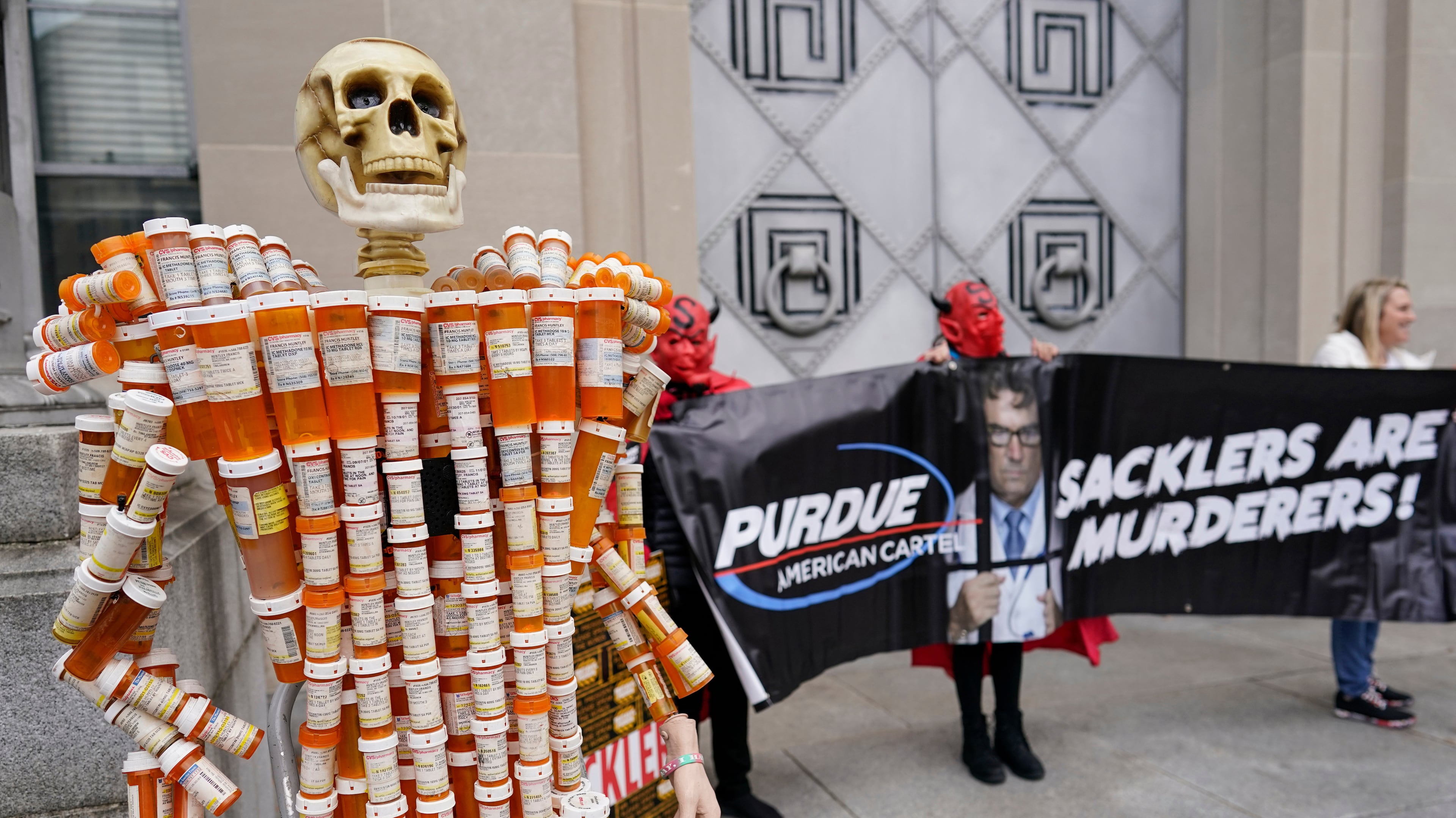 FILE - "Pill Man" made by Frank Huntley of Worcester, Mass., from his opioid prescription pill bottles, is displayed during a protest by advocates for opioid victims outside the Department of Justice, Dec. 3, 2021, in Washington. (AP Photo/Carolyn Kaster, File)