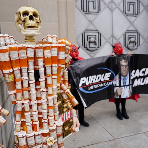 FILE - "Pill Man" made by Frank Huntley of Worcester, Mass., from his opioid prescription pill bottles, is displayed during a protest by advocates for opioid victims outside the Department of Justice, Dec. 3, 2021, in Washington. (AP Photo/Carolyn Kaster, File)
