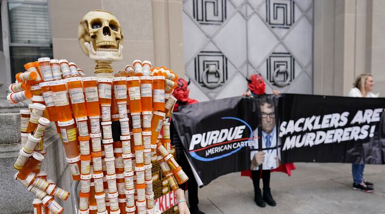 FILE - "Pill Man" made by Frank Huntley of Worcester, Mass., from his opioid prescription pill bottles, is displayed during a protest by advocates for opioid victims outside the Department of Justice, Dec. 3, 2021, in Washington. (AP Photo/Carolyn Kaster, File)