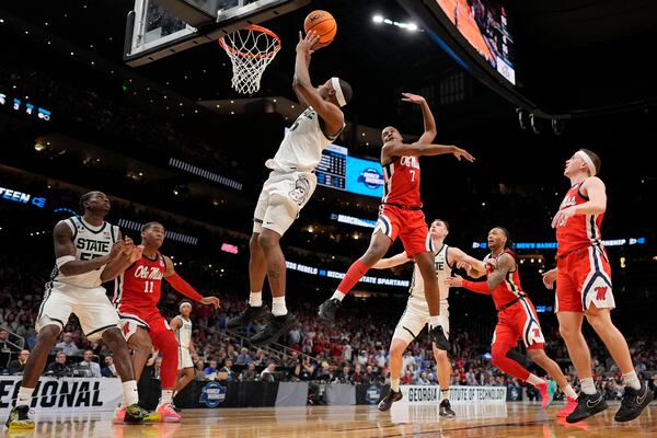 Michigan State forward Coen Carr (55) shoots against Mississippi guard Davon Barnes (7) during the second half in the Sweet 16 of the NCAA college basketball tournament, Friday, March 28, 2025, in Atlanta. (AP Photo/George Walker IV)
