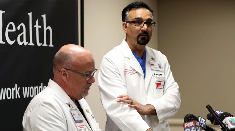 Chief Nursing Officer Dr. David Marshall, left, and Chief Medical and Clinical Officer Dr. Gulshan Sharma, who gestures around the area where Santa Fe Independent School District police officer John Barnes was shot, speak to the media at Jennie Sealy Hospital at the University of Texas Medical Branch in Galveston, Texas.