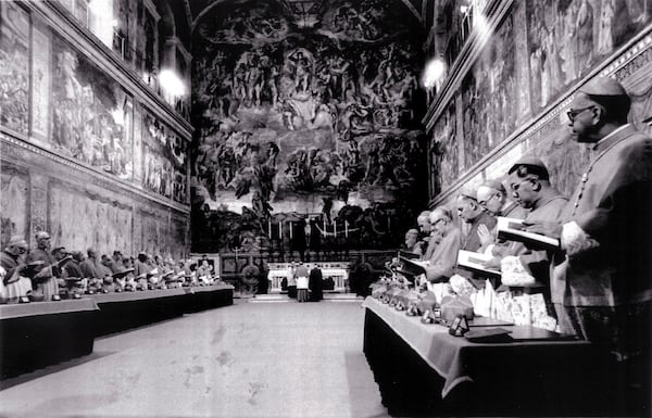 FILE - Cardinals stand in prayer inside the Sistine Chapel after they entered the conclave area for electing the successor of late John Paul I. In the background on the wall Michelangelo's famous fresco "The Last Judgement", in this Oct. 14, 1978 file photo. (AP Photo/Pool, File)