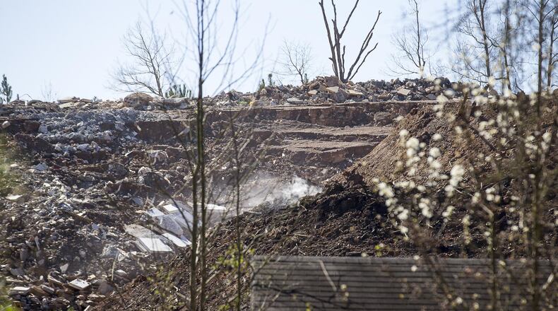 Smoke can be seen rising from piles of dirt and debris at an unlicensed landfill, located at 7635 Bishop Road, in South Fulton on Wednesday, Feb. 13, 2019. (ALYSSA POINTER/ALYSSA.POINTER@AJC.COM)