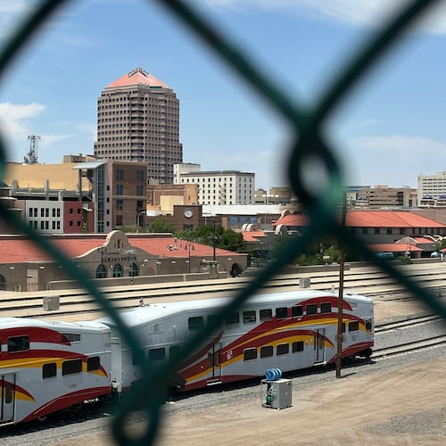 The tallest building in downtown Albuquerque, N.M., which houses the U.S. attorney's office, is seen beyond a chain link fence on Friday, June 12, 2026. (AP Photo/Susan Montoya Bryan)