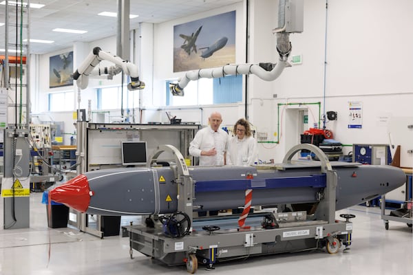 Louise Holmes, MBDA UK Deputy Managing Director, shows Britain's Defence Secretary John Healey, left, a storm shadow missile on an assembly line at the MBDA Storm Shadow factory in Stevenage, England, Saturday May 31, 2025. (Dan Kitwood/Pool via AP)