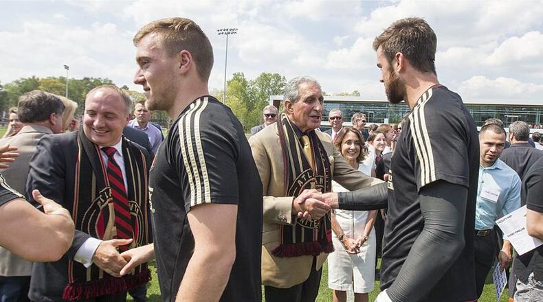 Atlanta United President Darren Eales, left, and Owner and Chairman Arthur Blank get congratulatory handshakes and thanks from star players Julian Gressel and goalie Alec Kann on Tuesday, April 11, 2017, at the team's new training facility in Marietta, Ga.