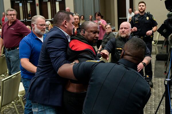 A protester is removed before a electronic non-leathal device was used as Rep. Marjorie Taylor Greene, R-Ga., speaks during a town-hall style meeting, Tuesday, April 15, 2025, in Acworth, Ga. (AP Photo/Mike Stewart)