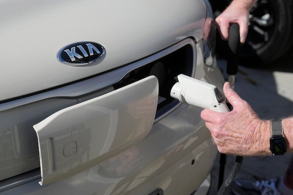 FILE - Ken Honeycutt demonstrates charging his Kia Soul electric vehicle in San Lorenzo, Calif., Nov. 9, 2024. (AP Photo/Jeff Chiu, File)