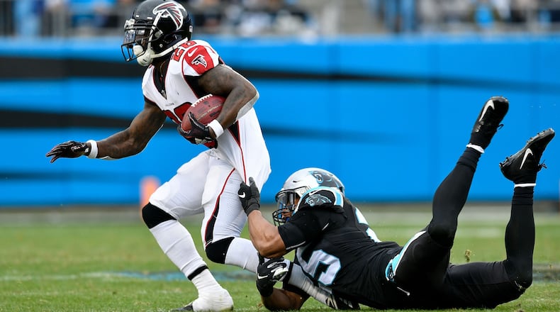 Tevin Coleman  of the Atlanta Falcons runs the ball against Eric Reid  of the Carolina Panthers in the third quarter during their game at Bank of America Stadium on December 23, 2018 in Charlotte, North Carolina. (Photo by Grant Halverson/Getty Images)
