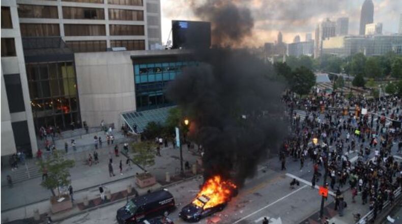 A group of demonstrators set fire to a police car Friday evening in downtown Atlanta.