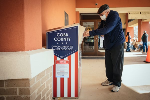 A man returns his absentee ballot on the first day of in-person early voting in the Senate runoff election at the Cobb County Elections Department in Marietta on Dec. 14, 2020. A federal judge ruled in 2024 that a conservative group’s efforts to challenge the eligibility of hundreds of thousands of voters in the Senate runoff elections in Georgia in early 2021 did not violate the Voting Rights Act under a clause outlawing voter suppression. (Audra Melton for The New York Times 2020)             