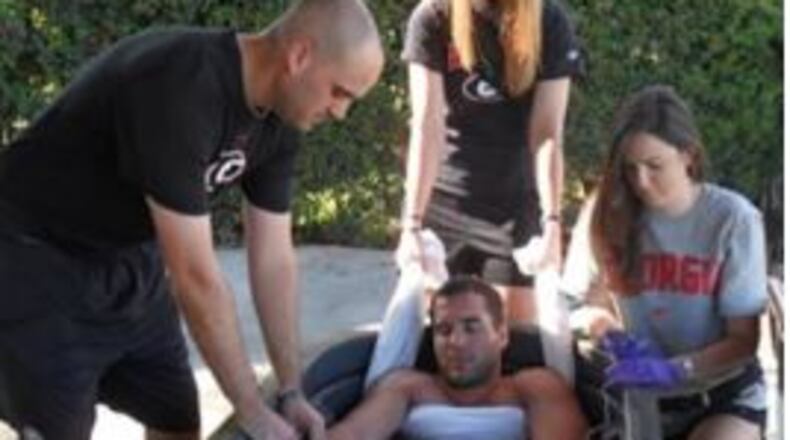University of Georgia staff and students simulate use of a cold immersion tub to treat heat exhaustion and heat stroke. The towel under the arms keeps the victim from drowning.
