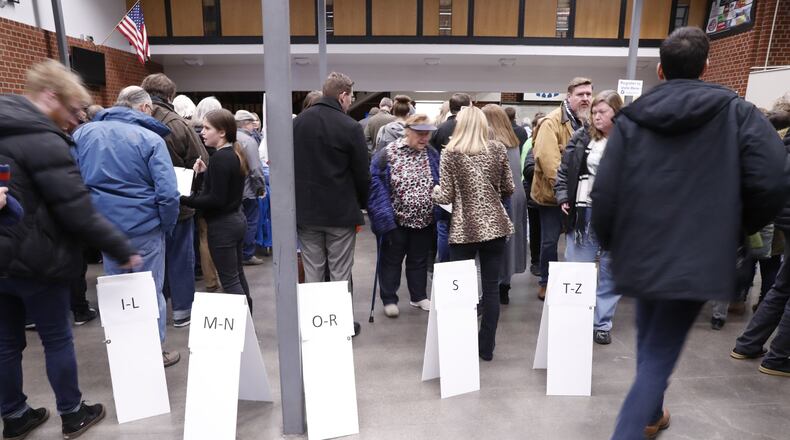 Signs guide caucus goers Monday as they arrive at Roosevelt High School in Des Moines, Iowa. (AP Photo/Andrew Harnik)