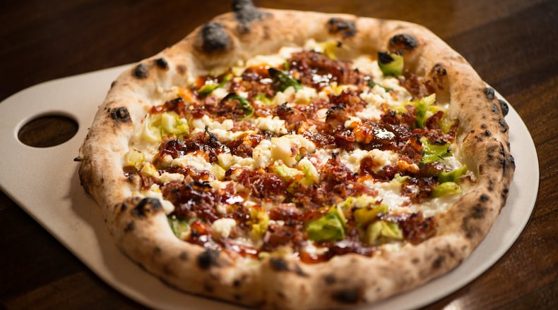 The Farmer's Market Pizza with mozzarella, brussels sprouts leaves, goat cheese, bacon bites, lemon zest, and bacon jam. Photo credit- Mia Yakel.