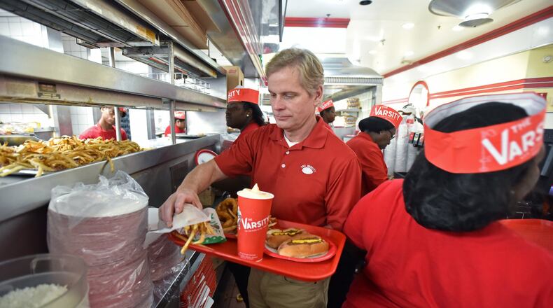 Gordon Muir, president of the Varsity, prepares a tray at the Varsity in Midtown Atlanta several years ago when the iconic restaurant was turning 90. HYOSUB SHIN / HSHIN@AJC.COM