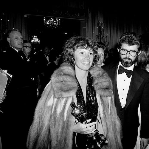 FILE - Marcia Lucas, wife of director George Lucas, right, carries her Oscar statuette as they arrive at a post Academy Awards party at the Beverly Hilton Hotel in Los Angeles, April 4, 1978. (AP Photo, File)