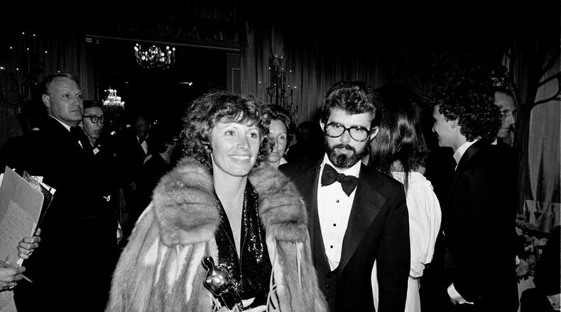 FILE - Marcia Lucas, wife of director George Lucas, right, carries her Oscar statuette as they arrive at a post Academy Awards party at the Beverly Hilton Hotel in Los Angeles, April 4, 1978. (AP Photo, File)
