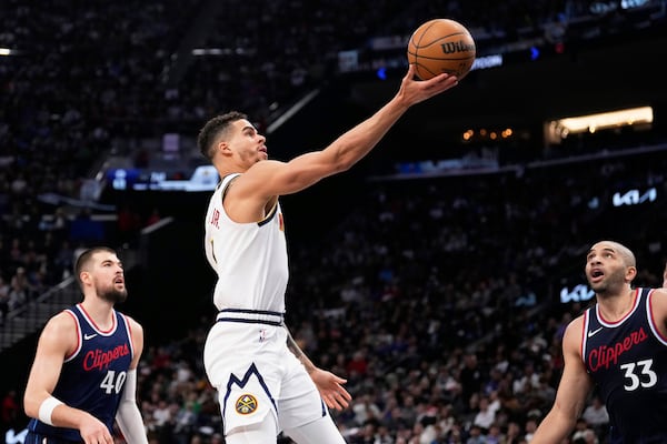 Denver Nuggets forward Michael Porter Jr., center, shoots as Los Angeles Clippers center Ivica Zubac, left, and forward Nicolas Batum defend during the second half in Game 6 of an NBA basketball first-round playoff series Thursday, May 1, 2025, in Inglewood, Calif. (AP Photo/Mark J. Terrill)
