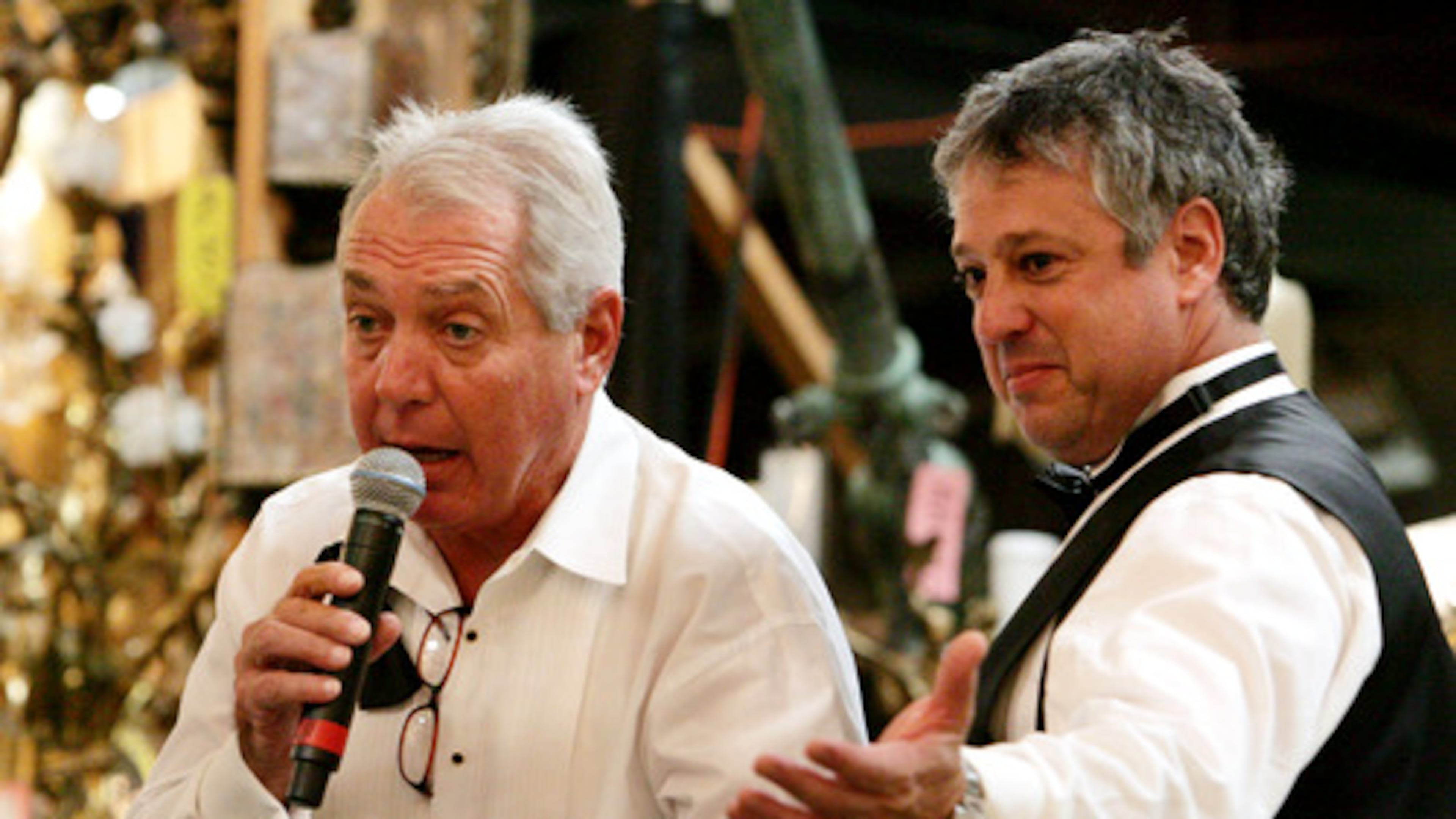Atlanta art and antiques appraiser and auctioneer Allan Baitcher (right) takes bids during a 2020 auction. Baitcher and his company, Peachtree Antiques, are being sued by a Florida multimillionaire who says he paid them $20 million for fakes. (AJC 2020)