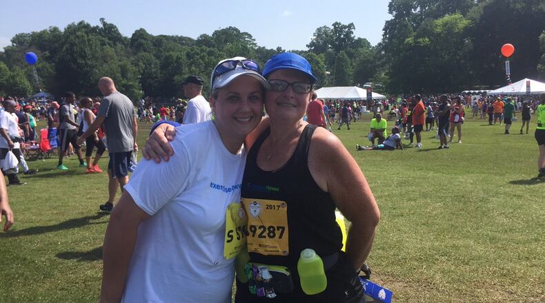 Kimberly Flowers, right, and Heni Jordan, left, completed the AJC Peachtree Road Race on Tuesday morning. Flowers has lost 113 pounds in the last 16 months.