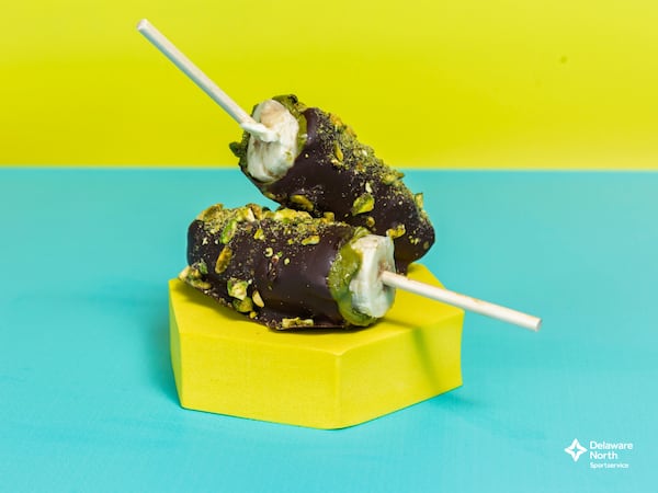 Two pieces of banana dipped in chocolate and sprinkled with pistachio pieces.