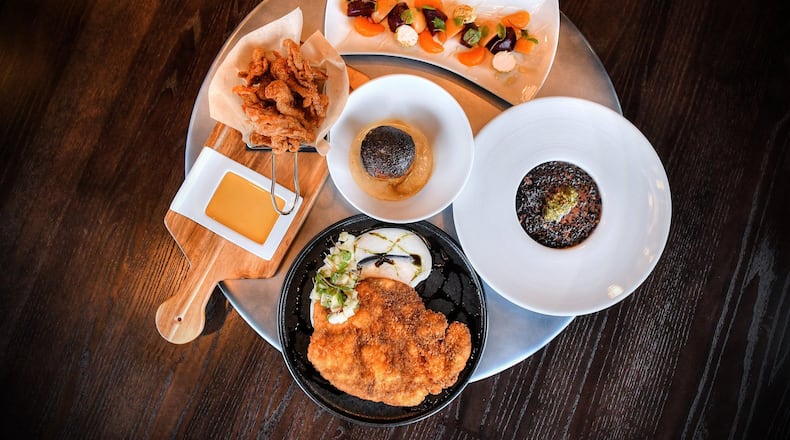 Dishes at owner Cory Harwell’s Carson Kitchen in Alpharetta: Young Beets, Black Rice & Oxtail Risotto, Pork Schnitzel, Crispy Chicken Skins, Glazed Donut Bread Pudding (center).  (Contributed by Chris Hunt Photography)