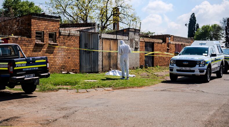 A forensic officer works at the scene where a sixth body, believed to be that of a woman, was found along a road in KwaThema, Springs, South Africa, Tuesday, Sept. 15, 2026. (AP Photo)