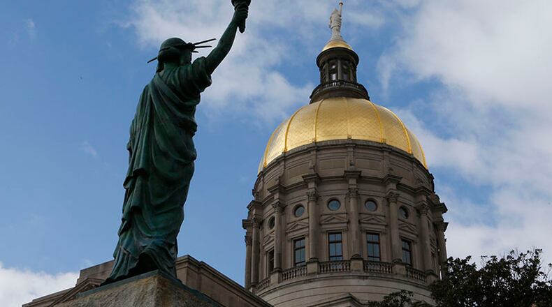 January 27, 2015 - Atlanta - The newly placed Statue of Liberty looks toward the Gold Dome. The statue was a gift from the Boy Scouts of America in the 1950's and is now located in Liberty Plaza across from the Capitol. Both the Senate and the House were in session today, With no bills ready for debate yet, both chambers focused on less serious matters. In the House, it was picture day (The Senate’s is Wednesday). The House and Senate each got a visit from representatives from the smokin’ hot Atlanta Hawks. BOB ANDRES / BANDRES@AJC.COM PHOTO BY BOB ANDRES / AJC