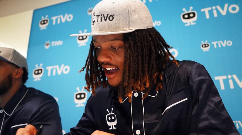 Georgia Tech wide receiver Malachi Carter signs his name, image and likeness deal with TiVo on August 20, 2021, an offer that was extended to each member of the team. He is wearing the TiVo-branded pajamas that were part of the deal. (Photo provided by Xperi)