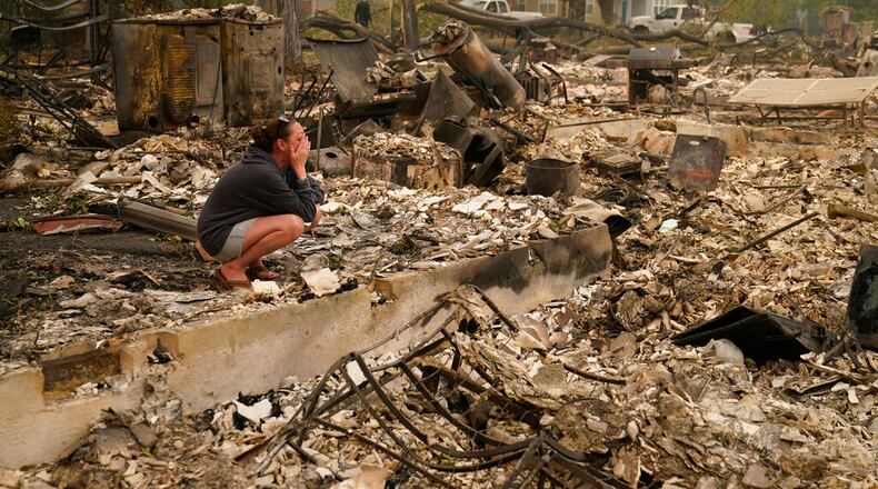 Desiree Pierce cries as she visits her home destroyed by the Almeda Fire, Friday, Sept. 11, 2020, in Talent, Ore. "I just needed to see it, to get some closure," said Pierce. (AP Photo/John Locher)