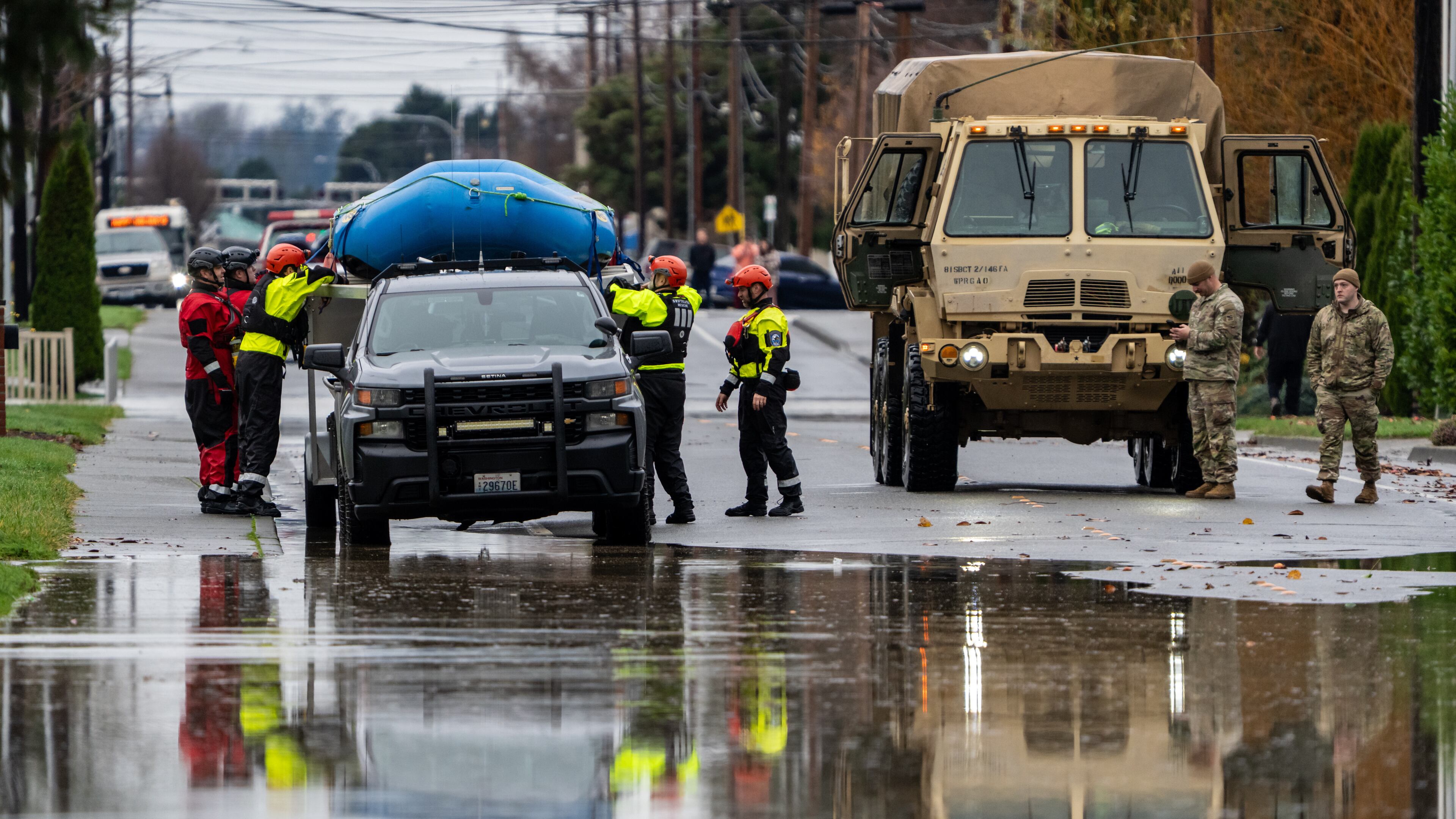 Emergency crews, including National Guard soldiers, wort in a neighborhood flooded by the Skagit River on Friday, Dec. 12, 2025, in Burlington, Wash. (AP Photo/Stephen Brashear)