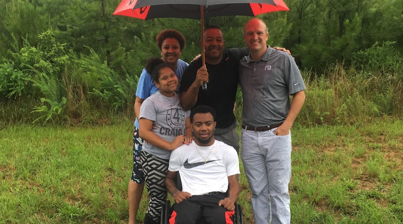 At the Jackson County lot chosen as the site for his new home, Devon Gales, center, is backed up by his sister, Teah, mother, Tish, father Donny and former Georgia linebacker Whit Marshall. (Photo courtesy Tish Gales)