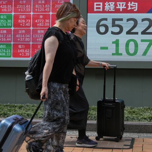 People walk past an electronic board showing Japan's Nikkei index at a securities firm Thursday, Aug. 6, 2026, in Tokyo. (AP Photo/Eugene Hoshiko)