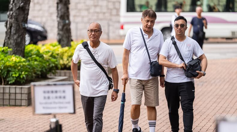 Yip Ka Kui, left, a family member of a victim of the last year's deadly fire, arrives for the independent committee hearing in Hong Kong, Wednesday, July 15, 2026. (AP Photo/Chan Long Hei)