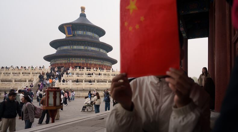 A children hold a Chinese national flag near the Hall of Prayer for Good Harvests at the Temple of Heaven in Beijing, China, Friday, April 3, 2026. (AP Photo/Vincent Thian)