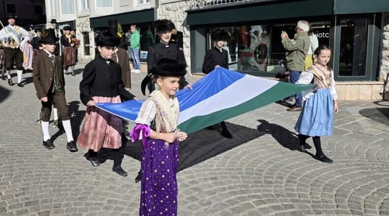 In this undated handout photo, people carry a traditional Ladin flag during a parade through the streets of Cortina D'Ampezzo, northern Italy, Monday, Jan. 26, 2026. (ULdA, Ampezzo Ladin Union via AP)