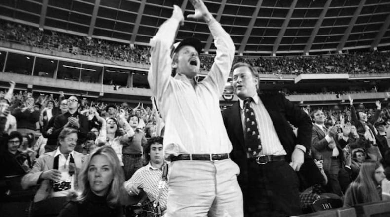 Ted Turner (center) celebrates as he watches the Braves play their home opener April 13, 1976. In Turner's first home game as the club's owner, the Braves lost 6-1 to the Reds. (Bud Skinner AJC 1976)
