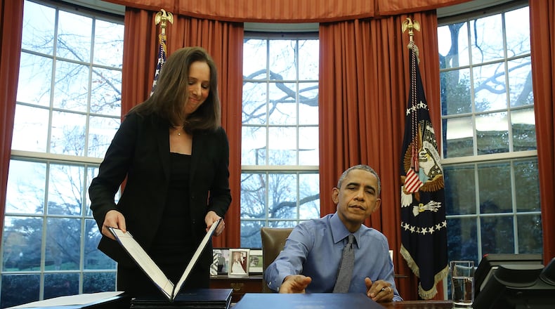 WASHINGTON, DC - DECEMBER 18: U.S. President Barack Obama is handed one of 12 bills from Staff Secretary Joani Walsh, to sign at his desk in the Oval Office at the White House December 18, 2015 in Washington, DC. Later today President Obama will travel to San Bernardino, California, to meet with families of the 14 victims of the recent mass shooting, before heading to Hawaii for Christmas vacation and return on January 3, 2015. (Photo by Mark Wilson/Getty Images)