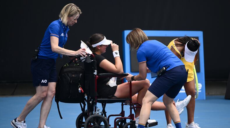Marina Stakusic of Canada is taken from the court in a wheelchair after retiring in her first round match against Priscilla Hon, right, of Australia at the Australian Open tennis tournament in Melbourne, Australia, Monday, Jan. 19, 2026. (Joel Carrett/AAP Image via AP)